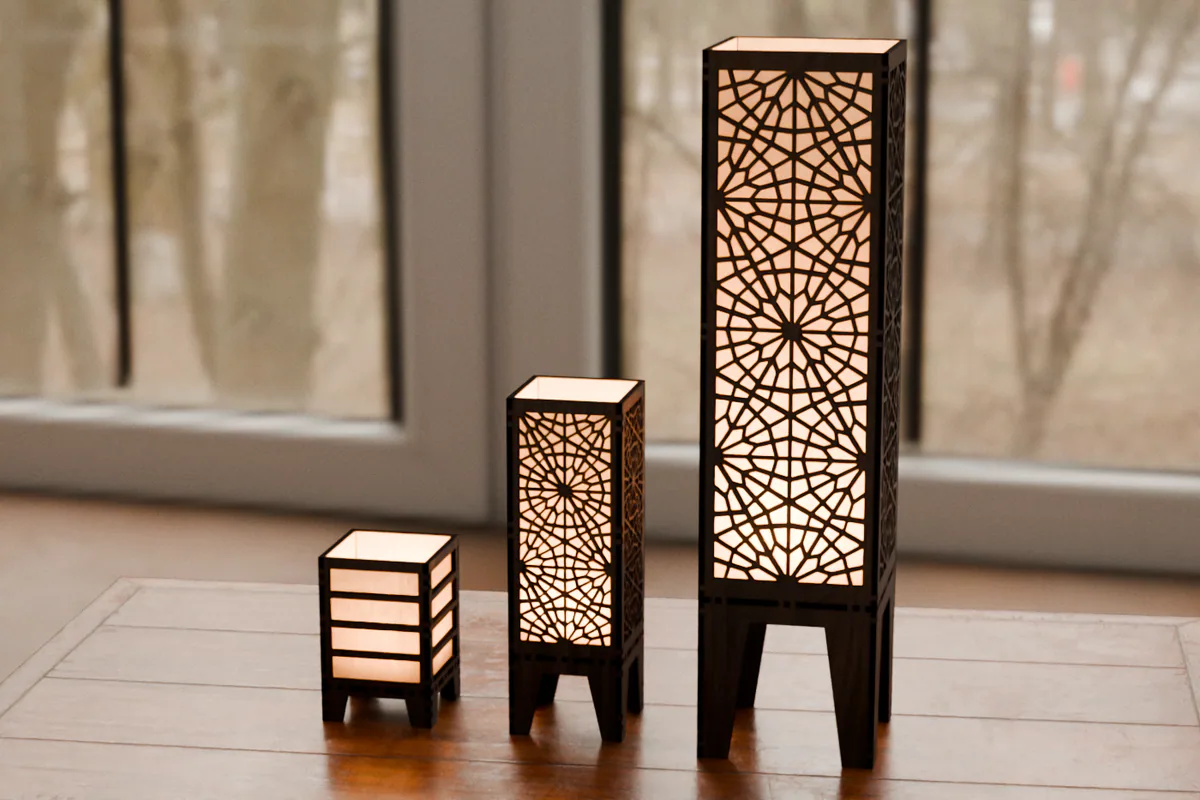 MiniLamp, MedLamp and LargeLamp in walnut, side by side on a table at dusk
